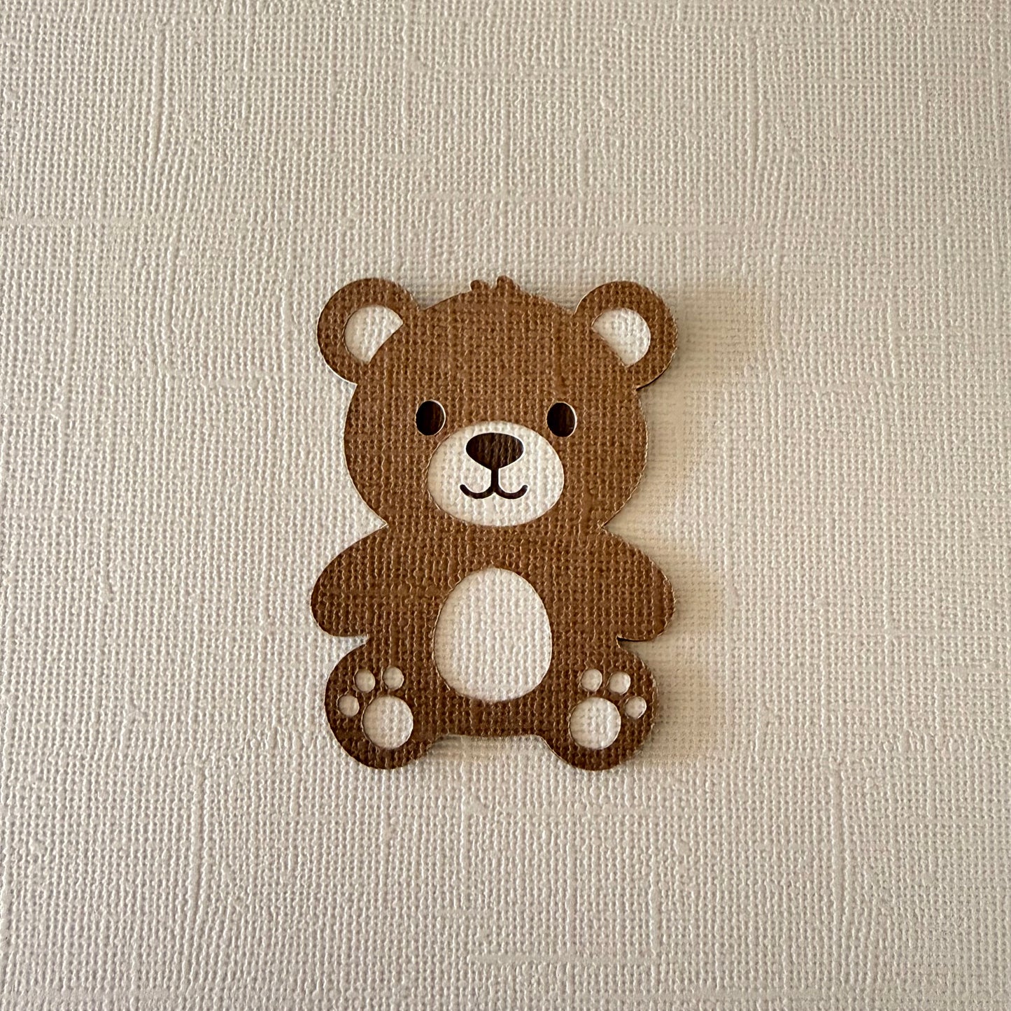 Brown teddy bear-shaped confetti on a beige textured background