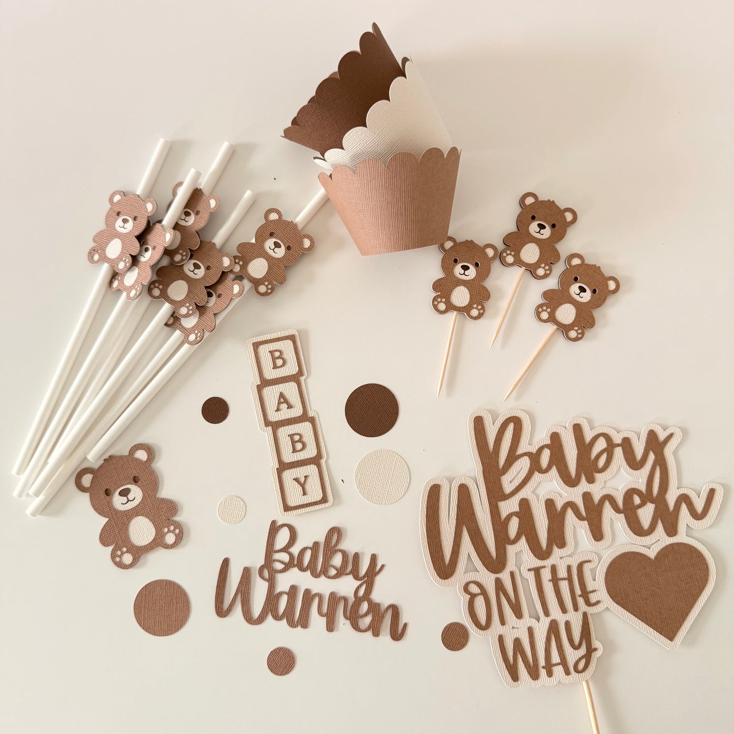 Baby shower decorations with teddy bears, 'Baby Warren' text, and polka dots on sticks.