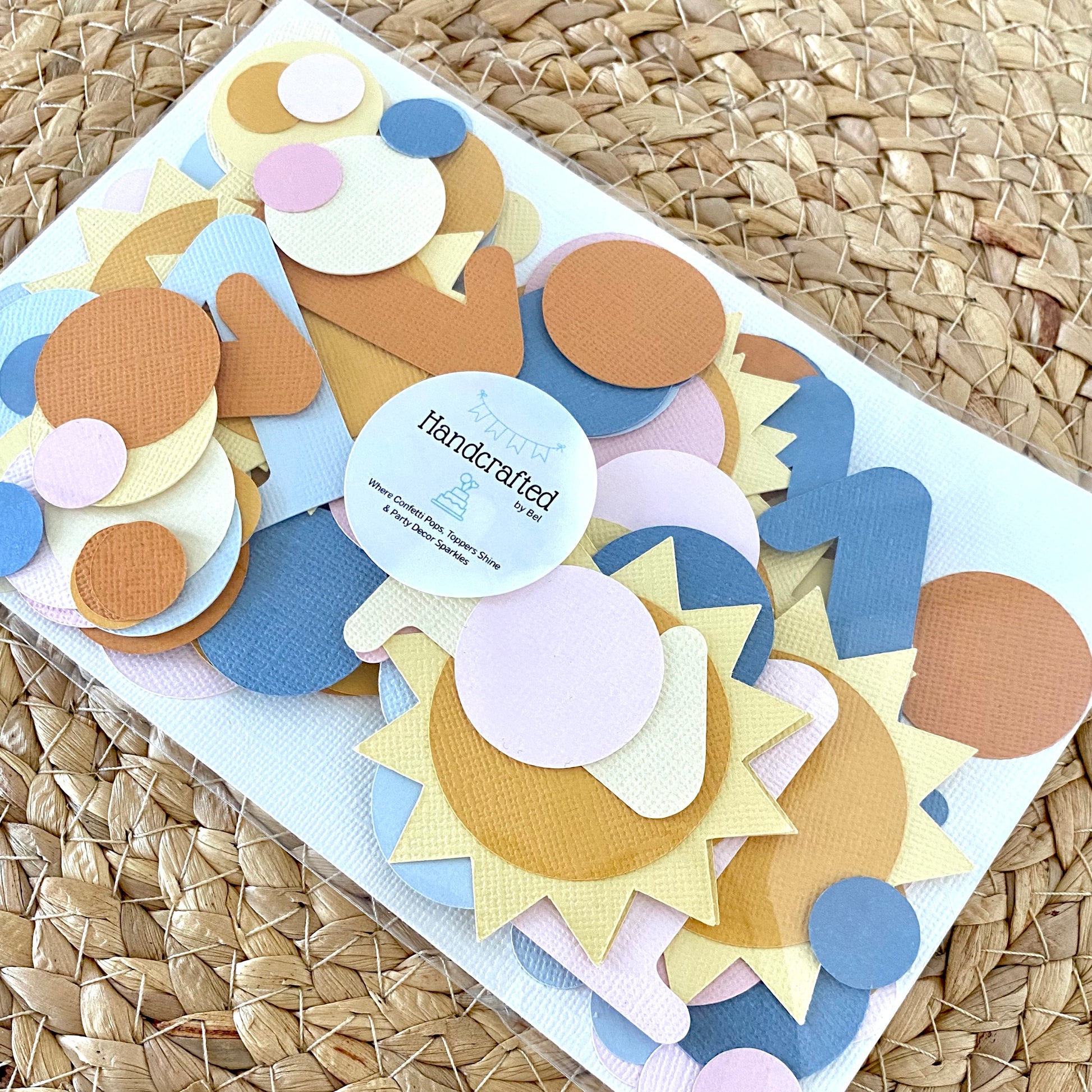 Colorful paper cutouts of shapes packaged up with Handcrafted label.