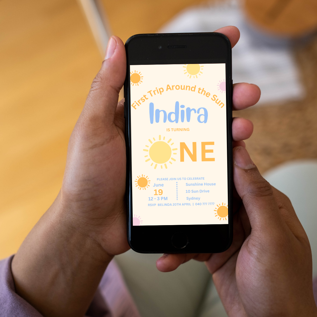 Person holding a smartphone displaying a birthday invitation for 'Indira'.