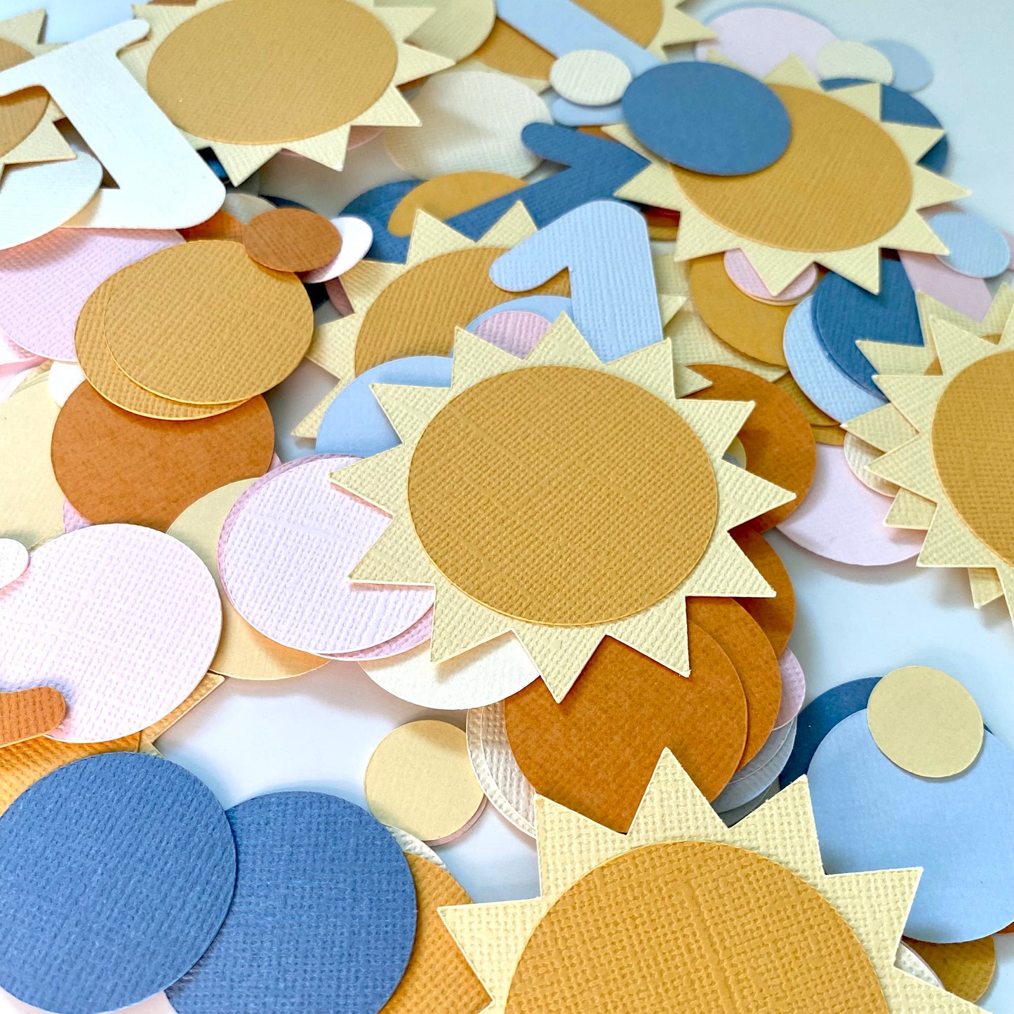 Colorful sun-shaped paper cutouts on a white background