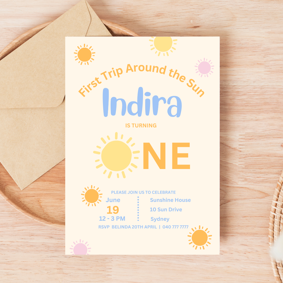 Birthday invitation card for a child's first birthday party with sun designs on a wooden surface.